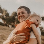 Brad smiling and hugging his daughter.