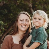 Claire smiling and holding her son.