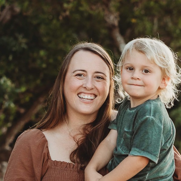Claire smiling and holding her son.