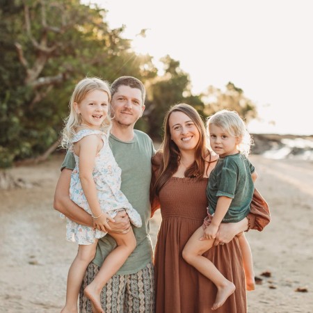 Brad and Claire at the beach holding their kids Evergrace and Lennox.